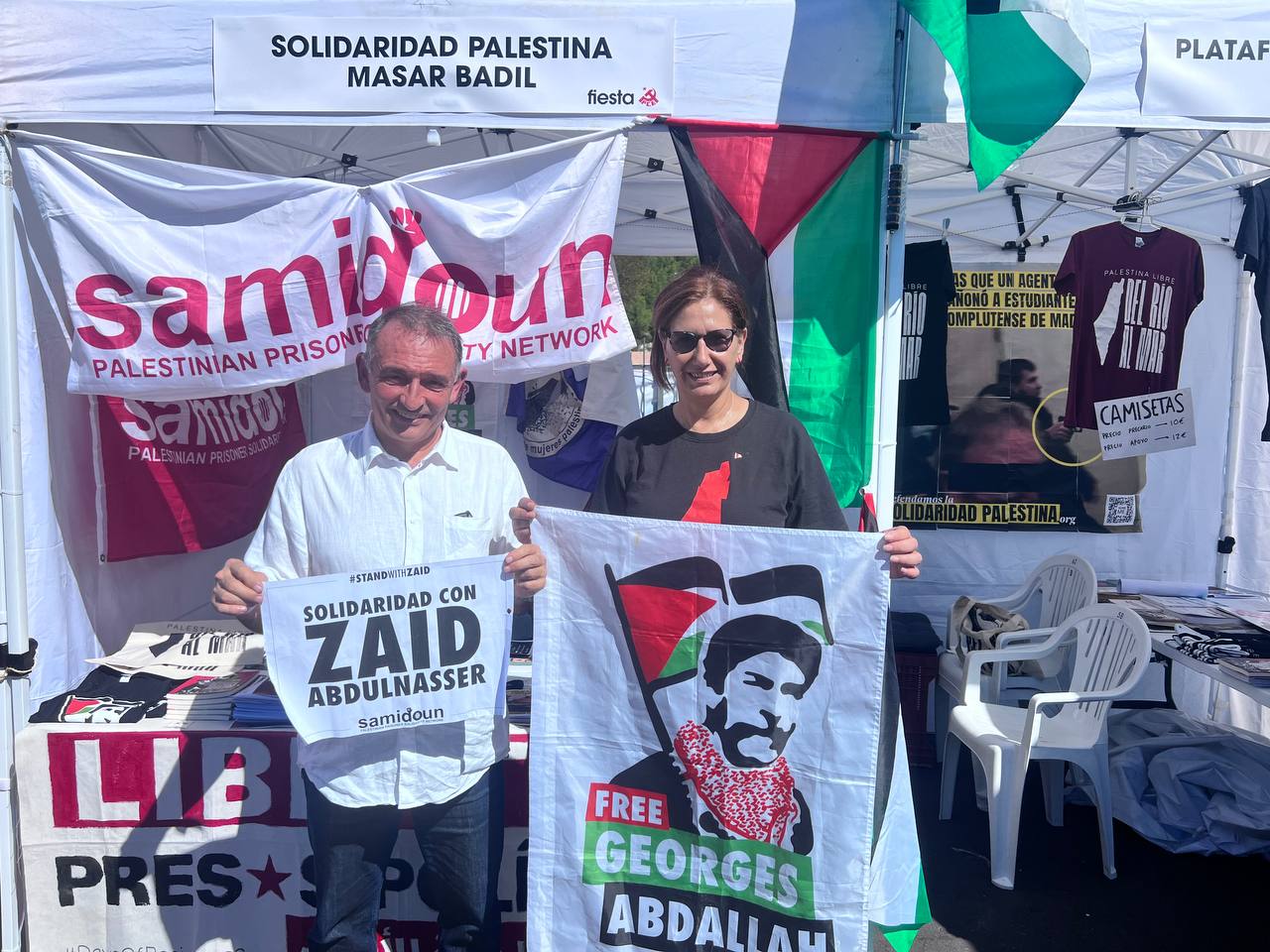 Enrique Santiago Y Jaldía Abubakrra con los carteles de la campaña de. solidaridad con George Abdalla y Zaid Abdul Nasser